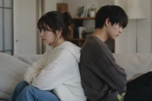 ソファで背中合わせに座る男女。期待した内容と違ったときの落胆を表したイメージ