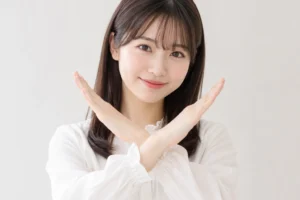 両手で×印を作る女性。ダウンロードには対応していないことを表したイメージ